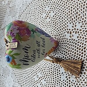 Heat thats has writing on it. " Mom listens with all her heart" with key stand.